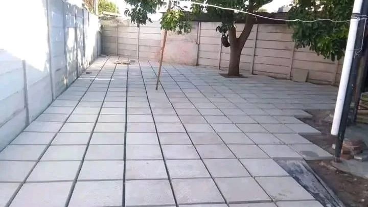 Garden paving in large grey concrete slabs across a back yard.