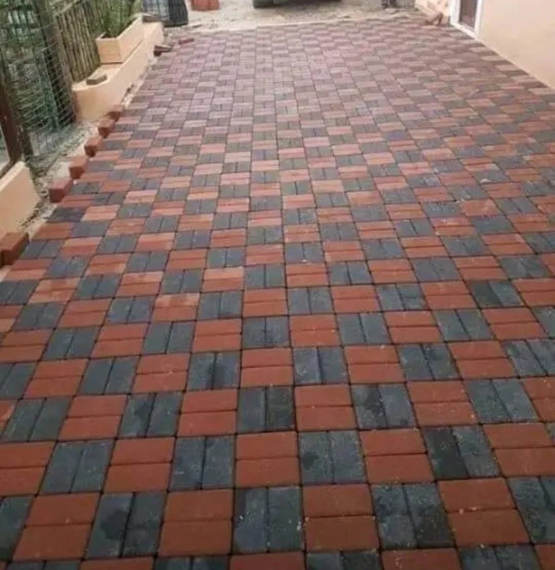 Basketweave paving pattern in alternating red and charcoal pavers.